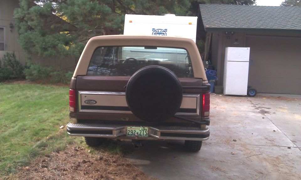 Brown Ford Bronco with spare tire on rear, tan top, and license plate 292 ZTS