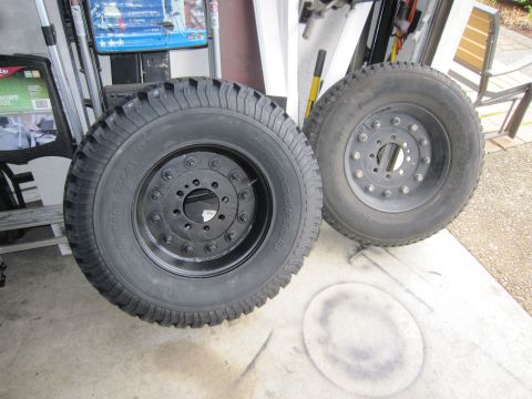 1996 Ford Bronco - Two large truck tires and rims are shown in a garage setting.