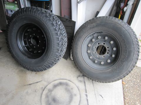 1996 Ford Bronco - A pair of tires and wheels are shown, one with a Goodyear brand tire and the other with a black rim and aggressive tread.