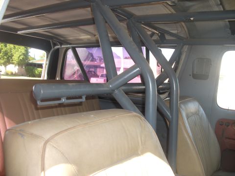 1979 Ford Bronco - The interior of a vehicle is shown, focusing on a custom roll cage structure installed over the seating area.