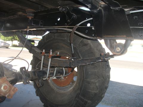 1979 Ford Bronco - Close-up view of the heavy-duty leaf spring suspension and rear axle assembly on a vehicle.