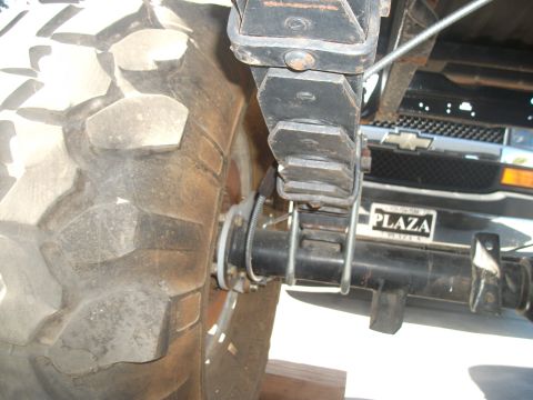 1979 Ford Bronco - Close-up of a vehicle's rear axle and leaf spring assembly, with another truck in the background.