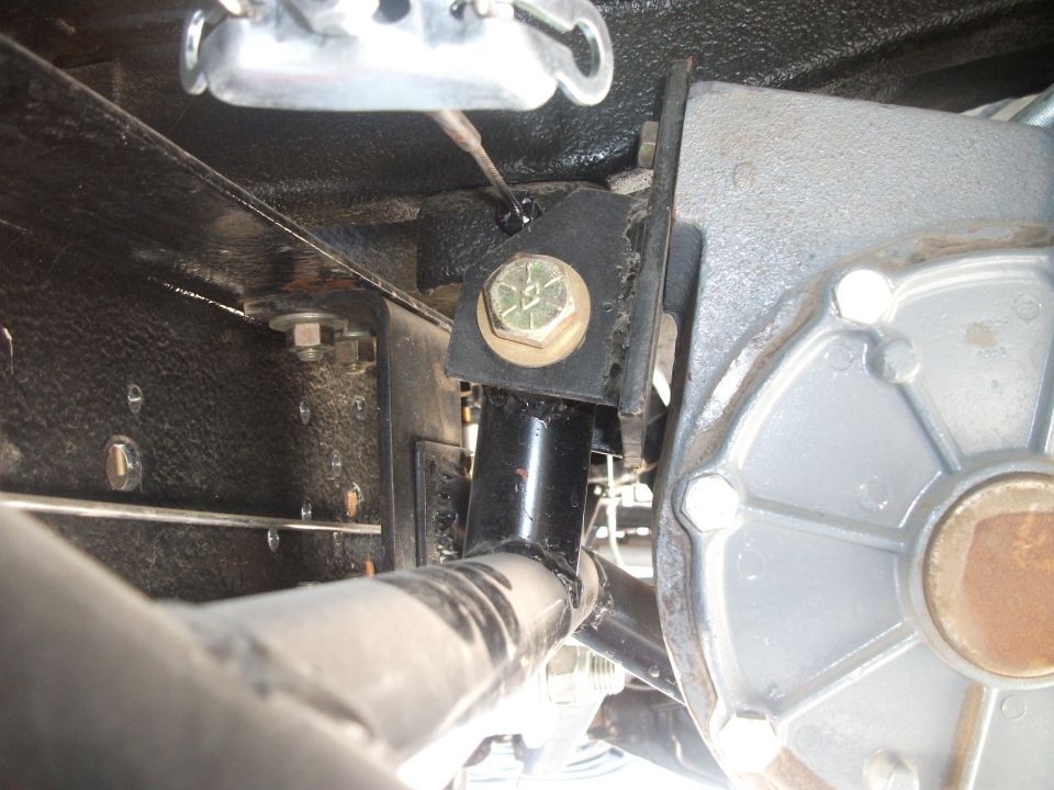 Black welded crossmember drivetrain mount with yellow-zinc bolt beside silver bellhousing
