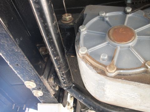1979 Ford Bronco - Close-up of a vehicle's transfer case, showing bolted housing and surrounding frame parts.