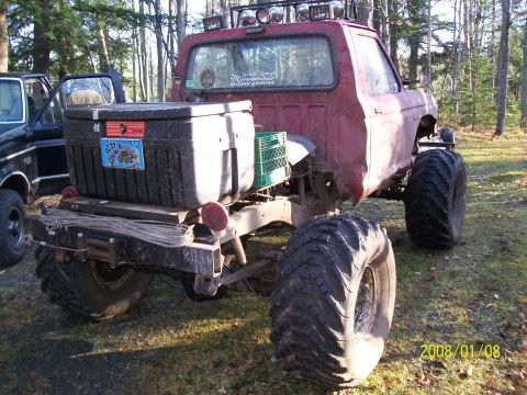 1988 Ford F-250 - Modified pickup truck with oversized tires and storage in the bed, parked outdoors with another vehicle nearby.