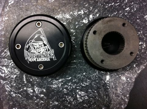 Suzuki Samurai - A black circular part the Undertakers 4x4 Arizona logo is shown next to a metal gear component.