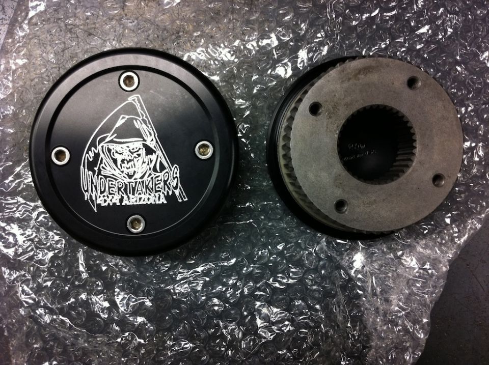 Black circular part with Undertakers 4x4 Arizona logo next to a metal gear