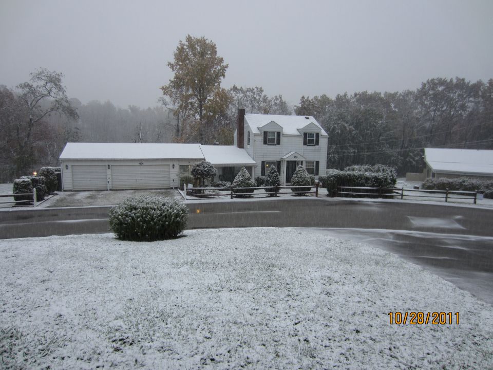White house and attached garage covered in snow, with a date stamp of 10/28/2011