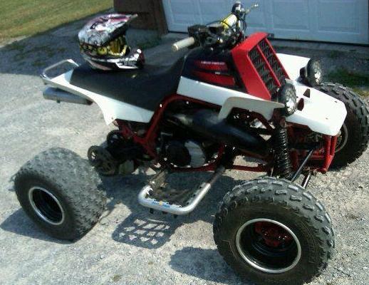 1995 Yamaha BANSHEE four-wheeler with white and red bodywork, black seat, and a helmet on top