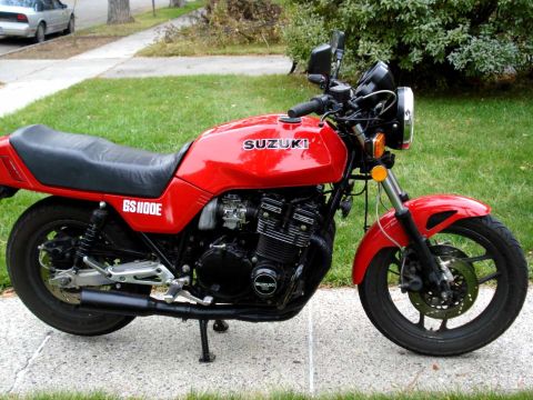 2008 Ford Crown Victoria - A red Suzuki GS1100E motorcycle is parked on a sidewalk with a car in the background.