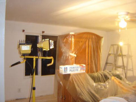 1984 Ford Mustang - Room prepared for painting, with furniture covered and work lights set up.