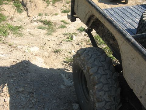 1987 Jeep Comanche - Rear wheel and fender of an off-road vehicle on a dirt path.