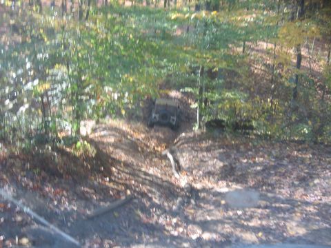 1987 Jeep Comanche - An off-road vehicle navigates a dirt path through a forest during daytime.