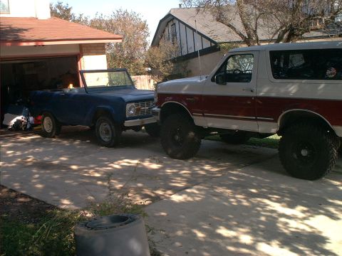 1971 Ford Bronco - Two Ford Broncos are parked in a driveway next to a garage.
