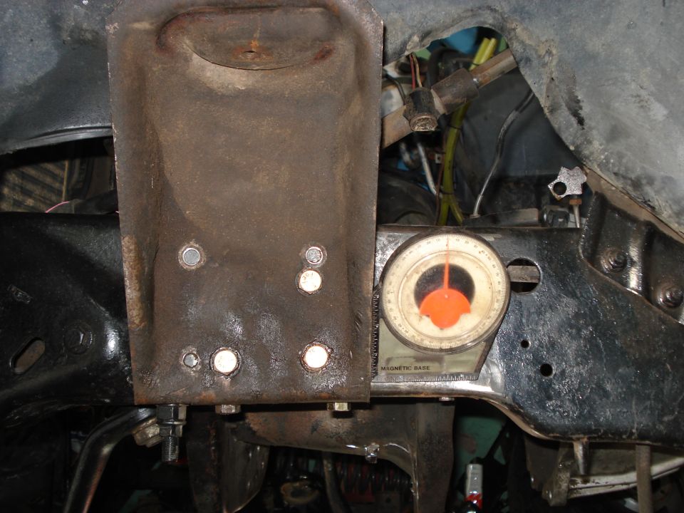 Close-up of rusty metal bracket with a magnetic base angle gauge attached to vehicle frame