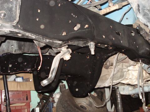 1980 Ford Bronco - Underside view of vehicle frame and suspension components during work.