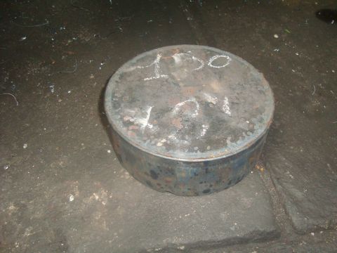 1980 Ford Bronco - A round metal part with chalk markings '150' and '421' is shown on a dark, textured surface.