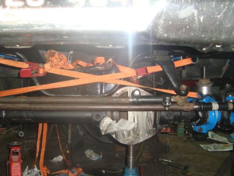 1980 Ford Bronco - The underside of a vehicle is shown, focusing on the differential and suspension components secured with orange straps.