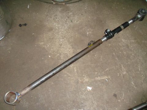 1980 Ford Bronco - A single steering linkage rod is shown lying on a concrete floor.