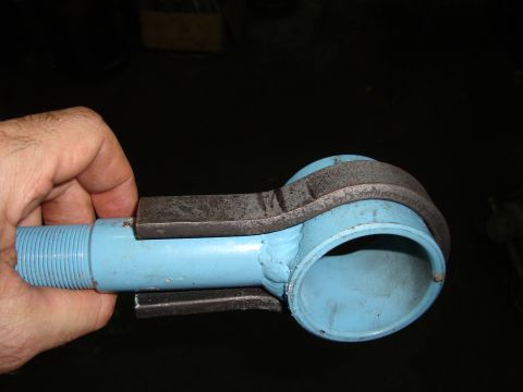 1980 Ford Bronco - A blue metal part, possibly a tie rod end, is held by a hand and a clamp.