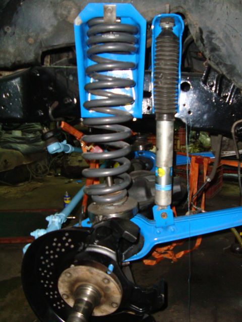 1980 Ford Bronco - Close-up of a vehicle's front suspension system, bright blue components and a large coil spring.