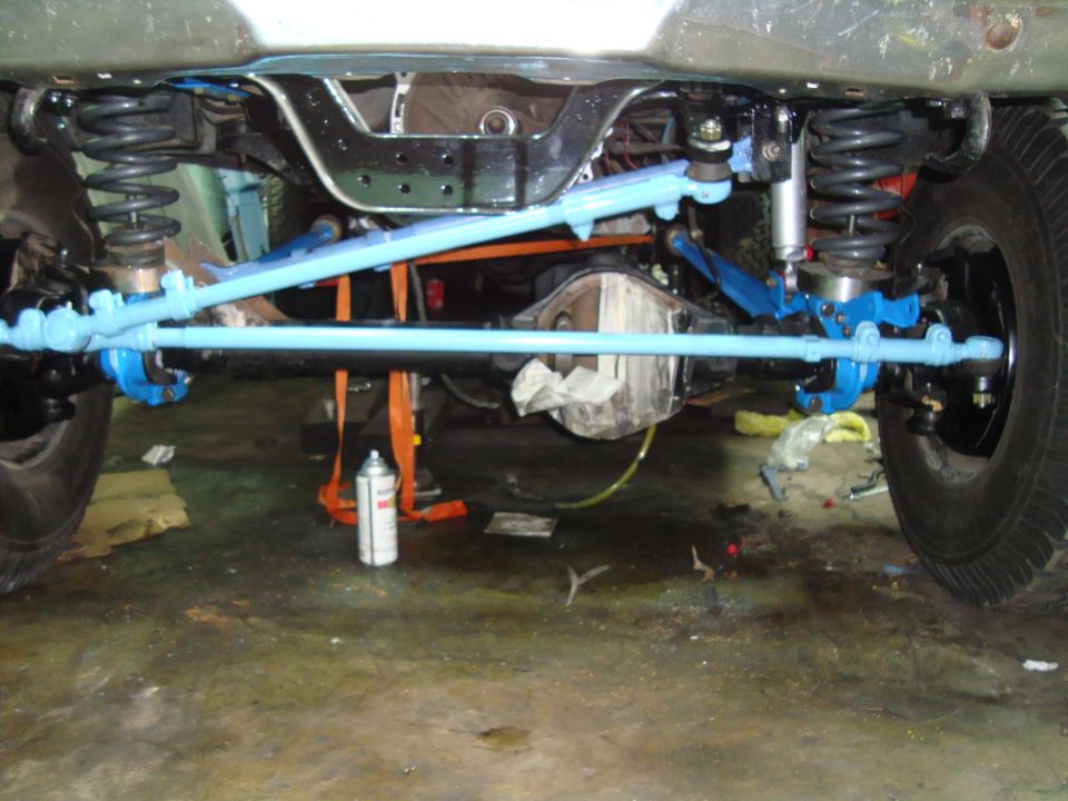Undercarriage of a vehicle with blue painted steering components and a Dana 44 axle