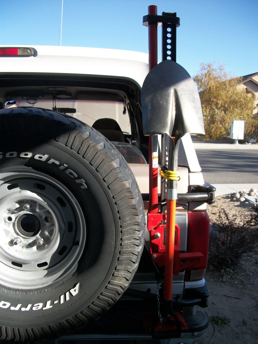 Spare tire and Hi-Lift jack mounted on rear of white SUV