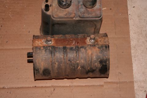 1989 Ford Bronco - Two heavily rusted automotive parts are shown on a cardboard surface.