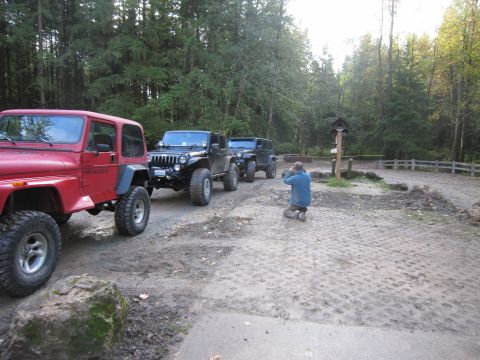 2008 Jeep Wrangler - Three Jeep Wranglers parked in a line on a dirt path, with a photographer kneeling to take a photo.