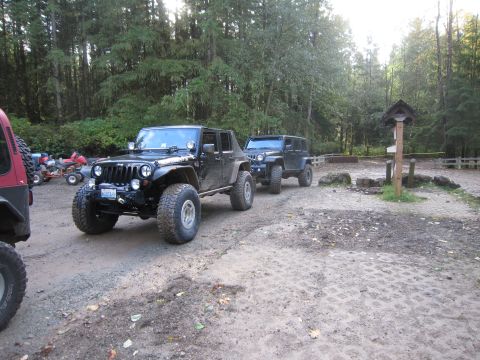 2008 Jeep Wrangler - Two Jeep Wranglers are parked on a dirt road in a forest clearing.