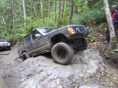 2008 Jeep Wrangler - Jeep Cherokee XJ navigating a rocky off-road trail with another vehicle in the background.