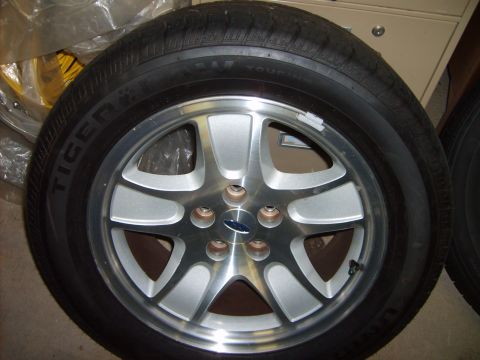 1993 Ford Crown Victoria - A single wheel and tire assembly is shown, with a visible Ford emblem on the wheel's hub.
