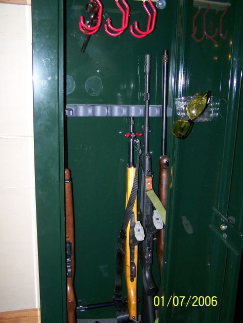 1989 Ford Bronco - Several firearms are organized inside a dark green gun safe, with a date stamp visible in the lower right corner.