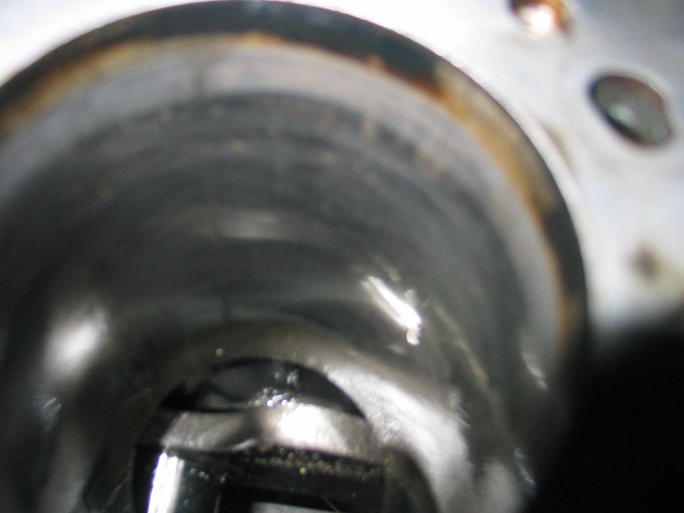 close-up of inside of an engine cylinder, showing wear and some oil