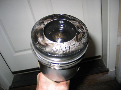 1984 Ford Bronco - A piston, likely from a diesel engine, shows significant carbon deposits and etched numbers on its crown.