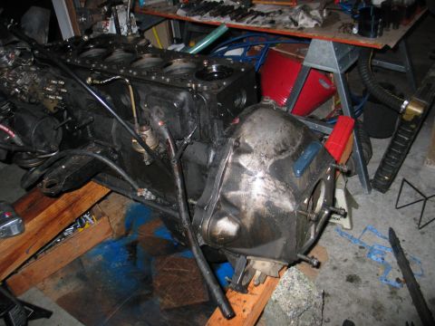 1984 Ford Bronco - Engine block and transmission assembly on wooden supports in a workshop setting.