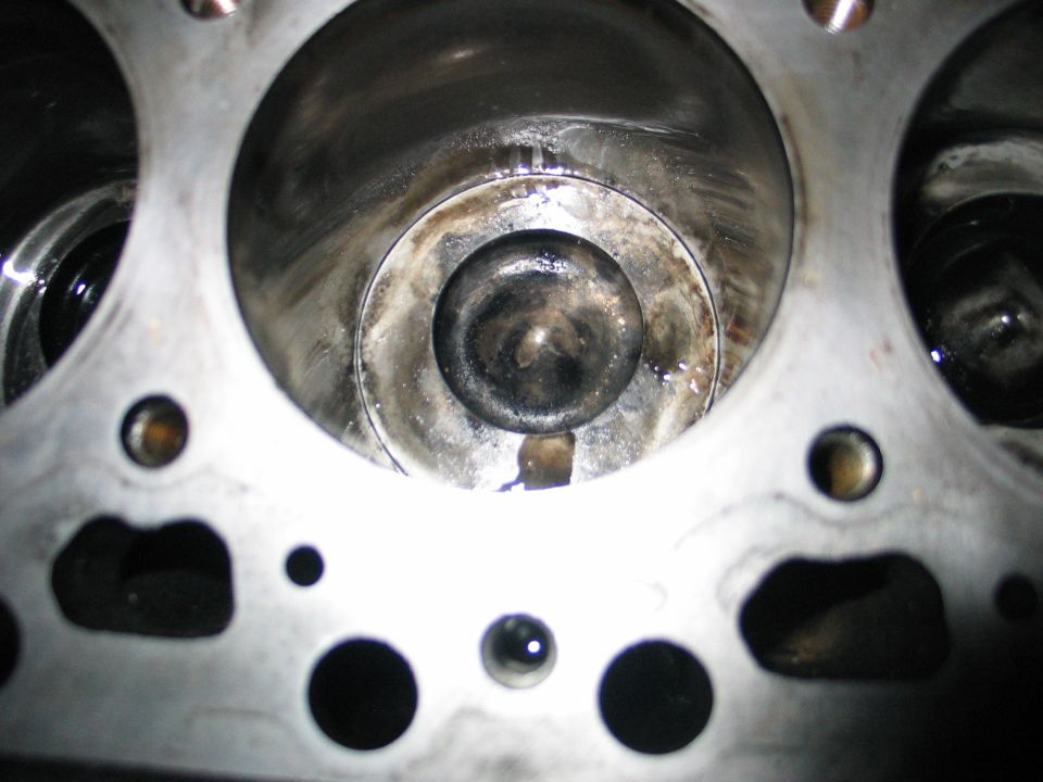 close-up of engine cylinder with valve visible, some oil residue