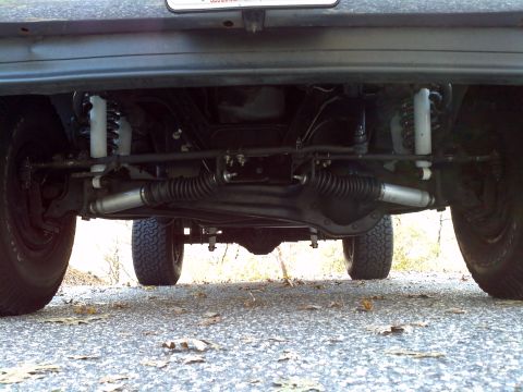 1993 Ford Bronco - A low-angle shot reveals the underside of a vehicle, focusing on its mechanical components and tires.