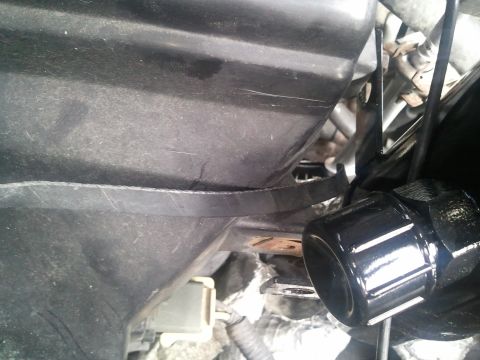 1994 Ford Bronco - Engine component detail shot showing a black, ribbed part with surrounding hoses and wiring.