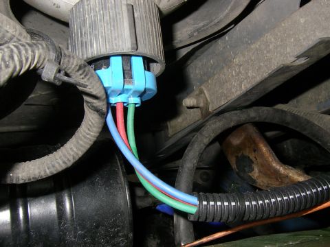 1990 Ford Bronco - Close-up of a vehicle's headlight harness connector, showing the wiring and housing details.