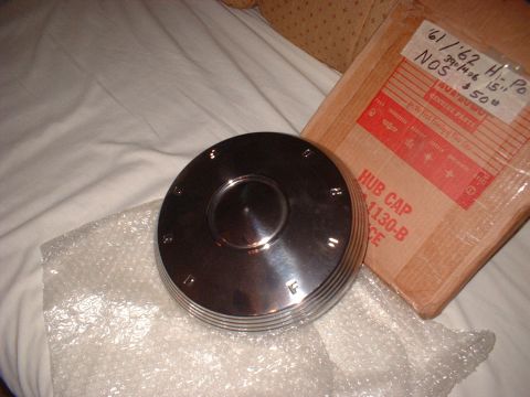 1971 Ford Ranchero - A chrome hub cap is shown next to its original packaging, which is labeled with part information.