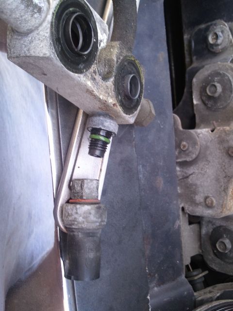1994 Ford Bronco - Close-up of an AC system component, showing a connection point and a hex bolt.