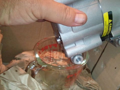 1994 Ford Bronco - Draining fluid from an automotive AC compressor into a measuring cup.