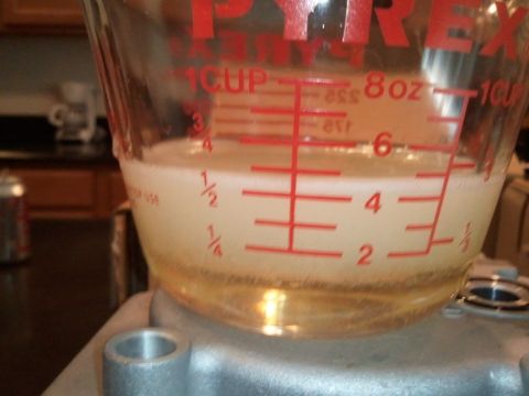 1994 Ford Bronco - A Pyrex measuring cup contains a foamy liquid, with clear liquid and sediment settled at the bottom.