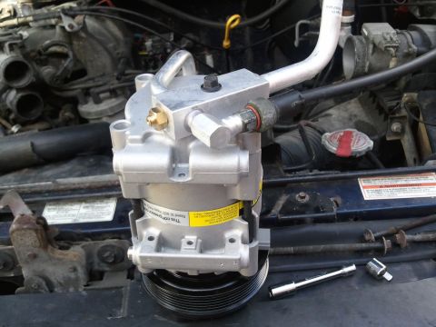 1994 Ford Bronco - AC compressor replacement in progress, showing the new part installed in the engine bay.