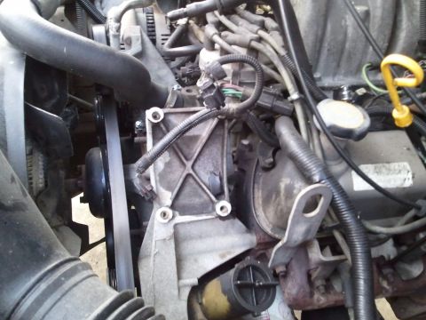 1994 Ford Bronco - This image shows various engine components, including hoses, wiring, and a belt system.