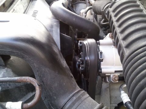 1994 Ford Bronco - Close-up of an AC compressor and fan assembly in an engine bay.