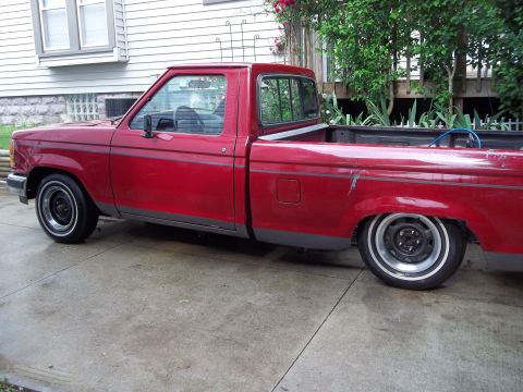 1970 Ford Ranchero - Side view of a red pickup truck, likely from the 1980s, with a lowered stance.
