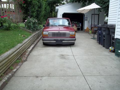 1970 Ford Ranchero - A red Ford Ranger pickup truck is parked in a driveway in front of a garage.
