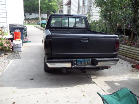 1970 Ford Ranchero - Rear view of a black pickup truck with a chrome bumper and tinted taillights.